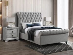 Grey upholstered sleigh bed with nightstands.