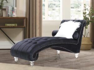 Black velvet chaise lounge with white pillow.