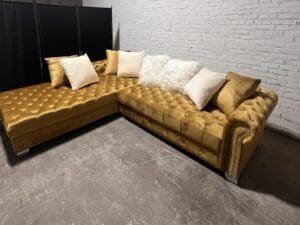 Gold velvet sectional sofa with pillows.
