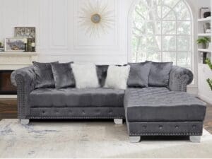 Gray velvet sectional sofa with ottoman.